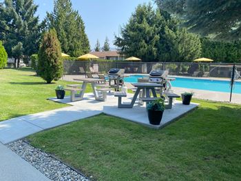 A group of picnic tables in a park next to a pool